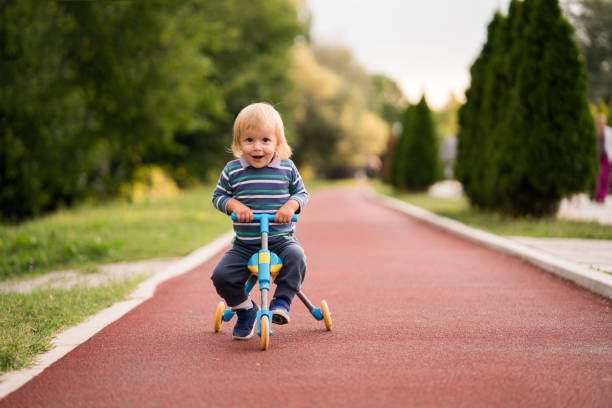 istock Cute little boy riding a tricycle in the park. 915630236