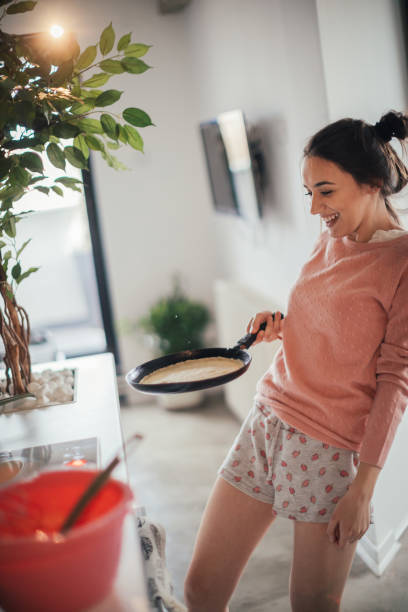 istock Young woman making pancakes 915630276