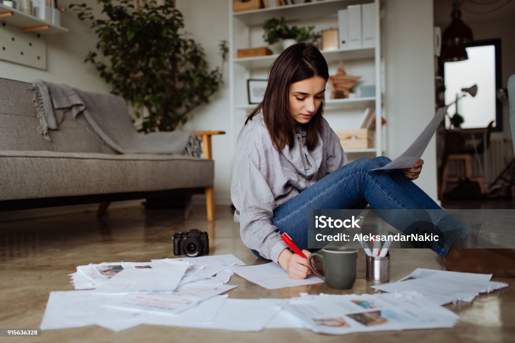 New project in the making Young woman working on a project on the floor of her future office Document Stock Photo