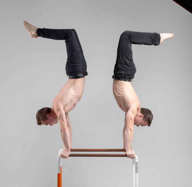 istock Two Male Gymnasts Practicing Calisthenics at Parallel Bars 915637770