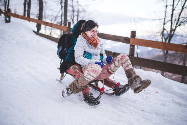 istock Playful Girls Sledding On Winter Holiday 915637816