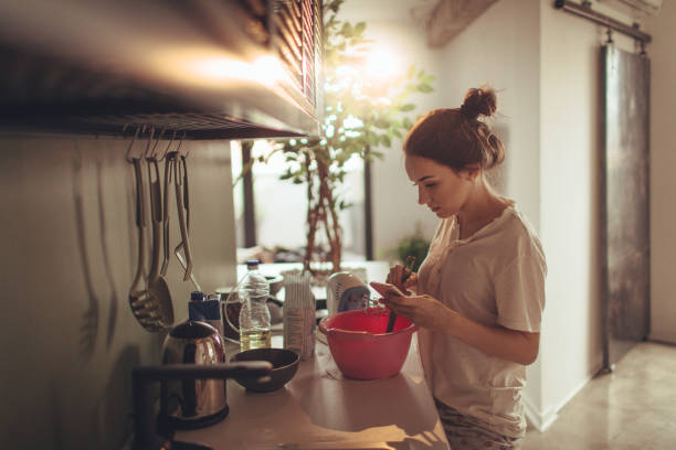 istock Young woman in the kitchen, reading recipe from the internet 915637936
