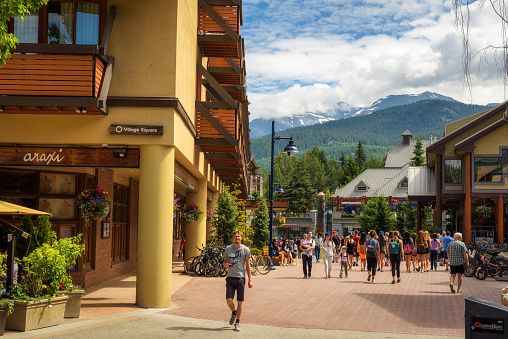 WHISTLER, BRITISH COLUMBIA, CANADA - JULY 2, 2017 : Scenic street view with many tourists  in Whistler Village. Whistler is a canadian resort town visited by over 2 million people annually.