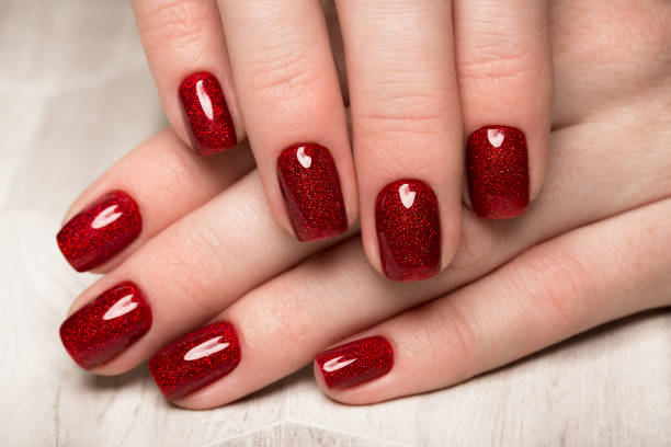 女性の手に明るいお祝いの赤のマニキュア。爪をデザインします。 - ネイルケア 写真 ストックフォトと画像