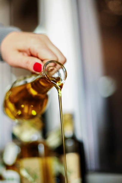 istock Pouring Olive Oil from Glass Bottle 915646116