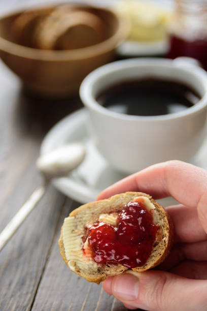 Breakfast with coffee, bread, butter and jam. Close up