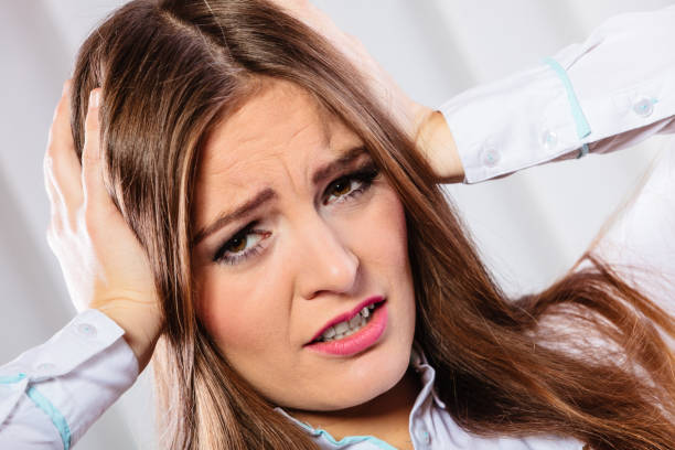istock stressed woman in white shirt with headache 915649090