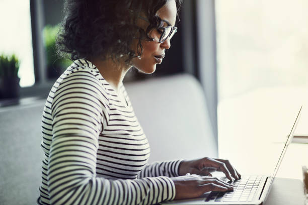 istock Young African woman working on a laptop at a table 915652390