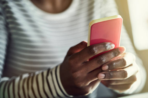 istock Young African woman reading text messages on her cellphone 915652772