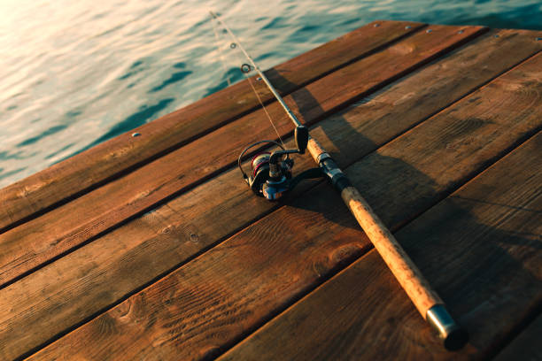 istock Fishing rod on a wooden background. 915652830