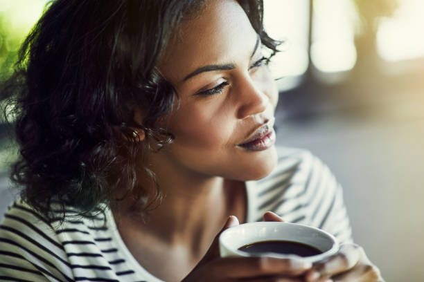 istock Young African woman drinking a coffee looking deep in thought 915653264