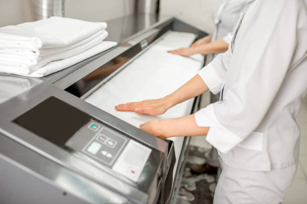 lavorare con una stiratrice professionale - iron laundry cleaning ironing board foto e immagini stock