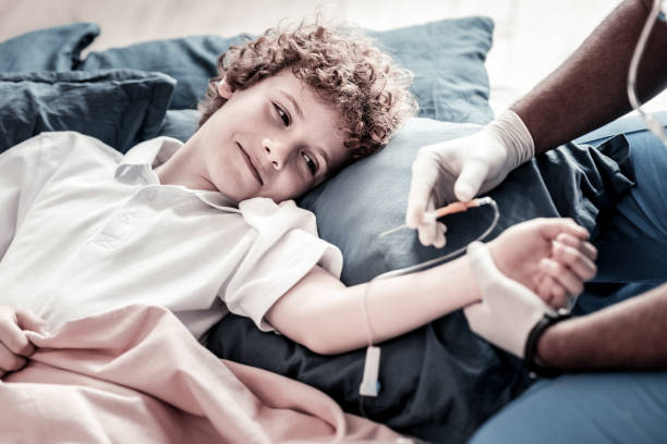 istock Brave teen boy watching medical worker inserting drip 915657070