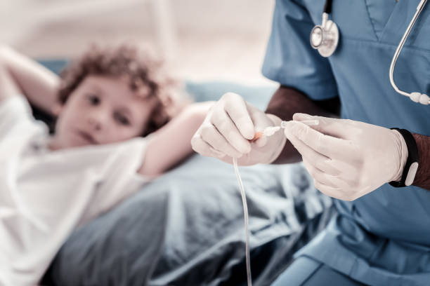 cerca de doctor ajuste goteo antes de la inserción - infusion needle fotografías e imágenes de stock