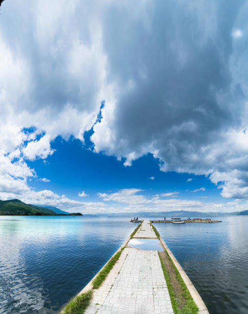 istock Empty boat port on calm water surface lake in Ohrid, Macedonia, sky copyspace, vertical 915657516