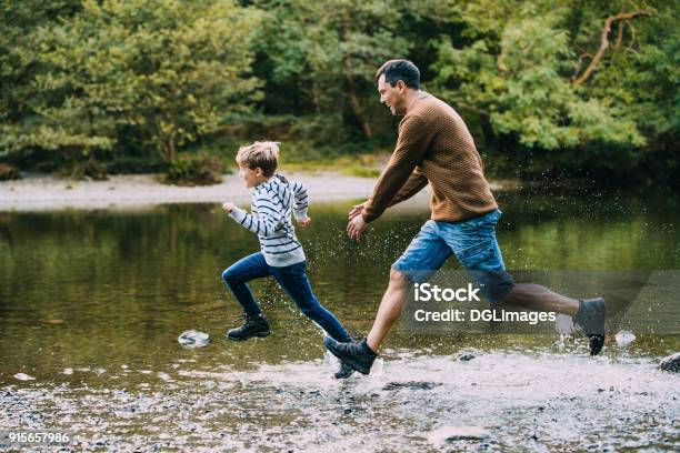 Being Chased In To The Water By Dad Stock Photo - Download Image Now - Child, Running, Chasing