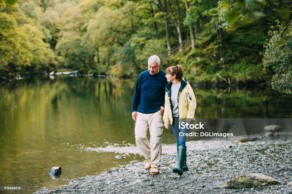 Senior pareja caminando alrededor de los lagos - Foto de stock de Andar libre de derechos