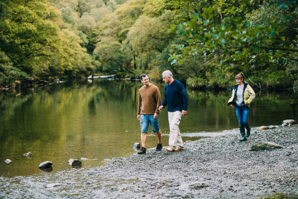 Family Hiking Round the Lake District Mid adult man is enjoying a walk around the Lake District with his parents. He is walking with his father and his mother is just behind them. keswick photos stock pictures, royalty-free photos & images