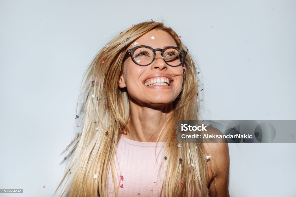 Party with a confetti Photo of a young woman celebrating her youth, beauty and femininity - tossing a confetti in the air while dancing Eyeglasses Stock Photo