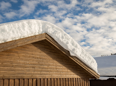 Snow on a garage roof in Brokke, Setesdal in Norway. Winter. Brown garage wall