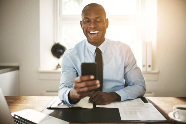 istock Smiling young businessman laughing at a cellphone message 915665172