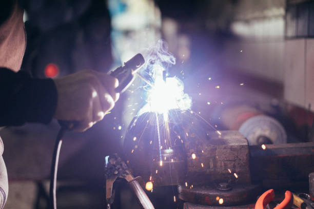 professional welder in a factory welding steel bars - ball bearing engineer machine part gear imagens e fotografias de stock