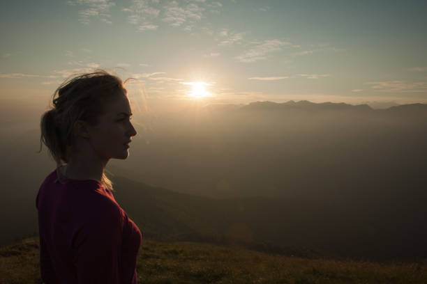 istock Woamn stands on a peak of mountain at sunset 915670496