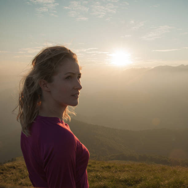istock Woamn stands on a peak of mountain at sunset 915670498