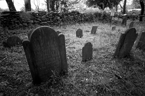 Tombstones in a small rural cemetary looks scary, black and white