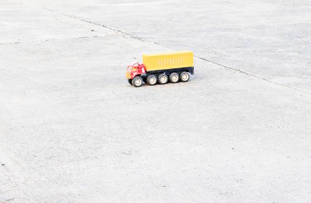 Plastic toy truck with bright colors on the empty concrete floor.