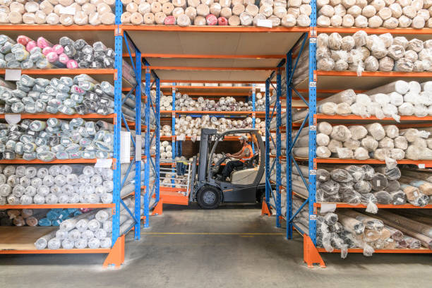 istock Man driving fork lift truck in carpet warehouse 915681240