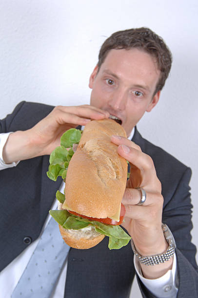 istock businessman eating a big sandwich 91568247