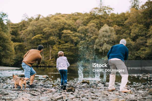 Three Generation Family Are Skimming Stones Stock Photo - Download Image Now - Family, Multi-Generation Family, Rock - Object