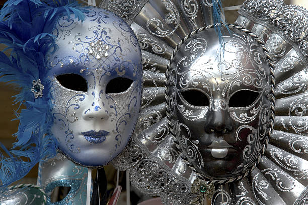 Close-up of a colorful Venetian mask with golden swirls and vibrant red and purple hues, representing the tradition and art of Venice's iconic carnival festivities under warm sunlight.