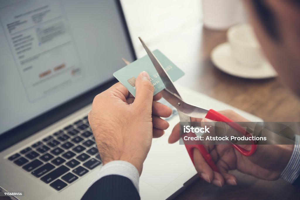 Credit card cancelled due to negligent usage Businessman cutting a credit card that canceled by financial institute due to negligent usage Credit Card Stock Photo