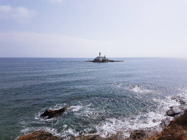 istock Lighthouse on the sea under sky 915688772