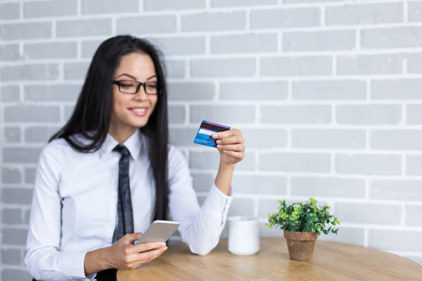 istock Young woman using credit card and smart phone 915689038