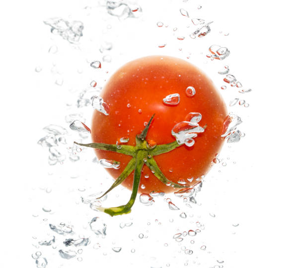 istock Red tomato under water on a white background 915689134