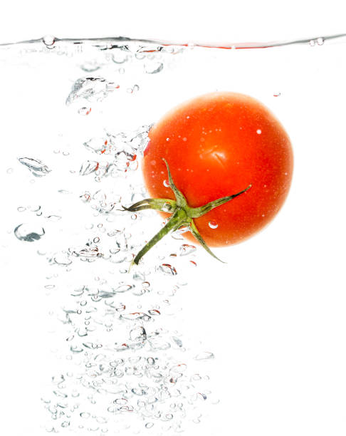 istock Red tomato under water on a white background 915689200