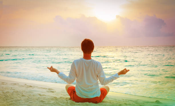 istock young man doing yoga at sunset tropical beach 915689704