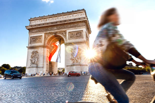 arc de triomphe in paris with a big french flag under it - paris france arc de triomphe france french culture imagens e fotografias de stock