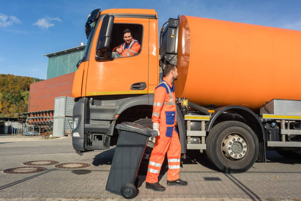 istock Two garbagemen working together on emptying dustbins 915690128