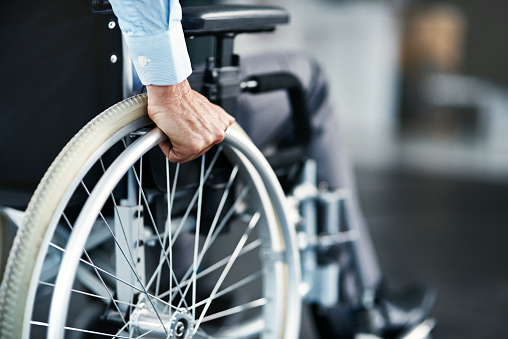 Closeup shot of an unrecognizable man sitting in a wheelchair
