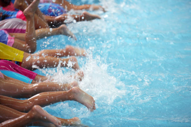 group of children at swimming pool class learning to swim group of children at swimming pool class learning to swim swimming stock pictures, royalty-free photos & images