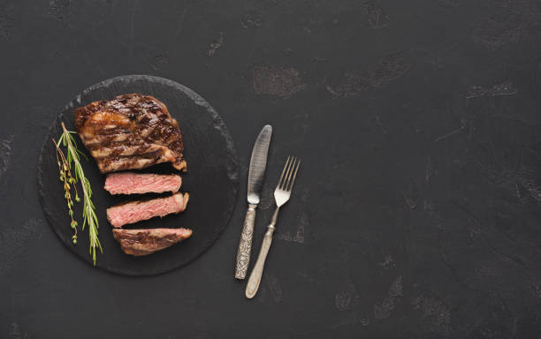 istock Rib eye steak and spices on black background 915697308