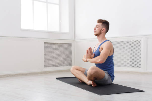 istock Man training yoga in lotus pose, copy space 915698476