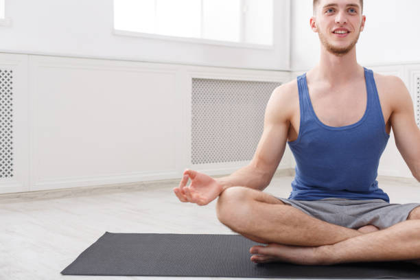 istock Man training yoga in lotus pose, copy space 915700188