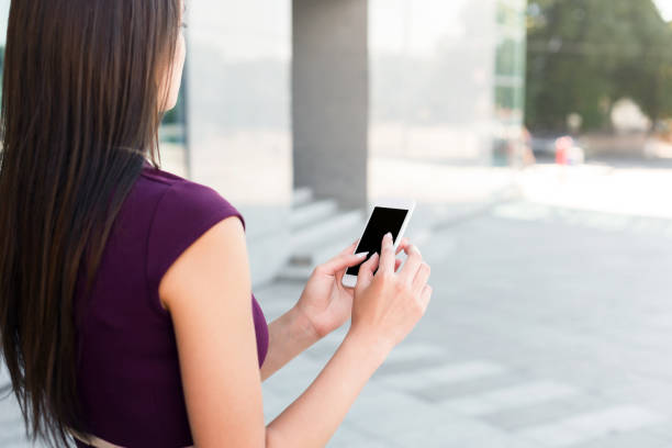 istock Young businesswoman using smartphone outdoors 915701842