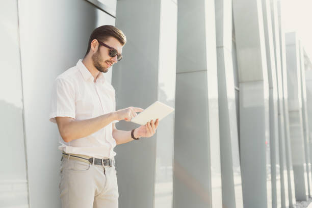 istock Smiling businessman working with tablet outdoors 915704616