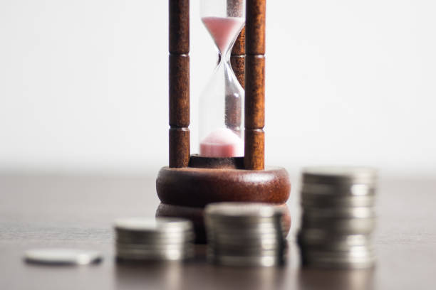 istock Sandglass and coin on white background. 915705532